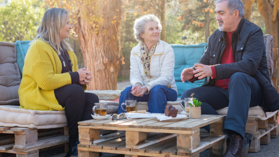 Older adults and community members enjoying conversation together outdoors in a welcoming social setting