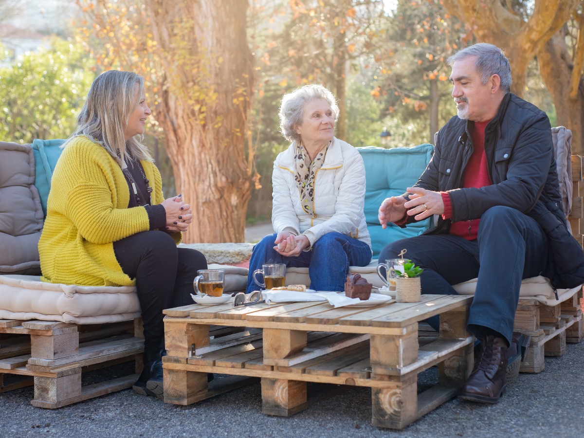 Older adults and community members enjoying conversation together outdoors in a welcoming social setting