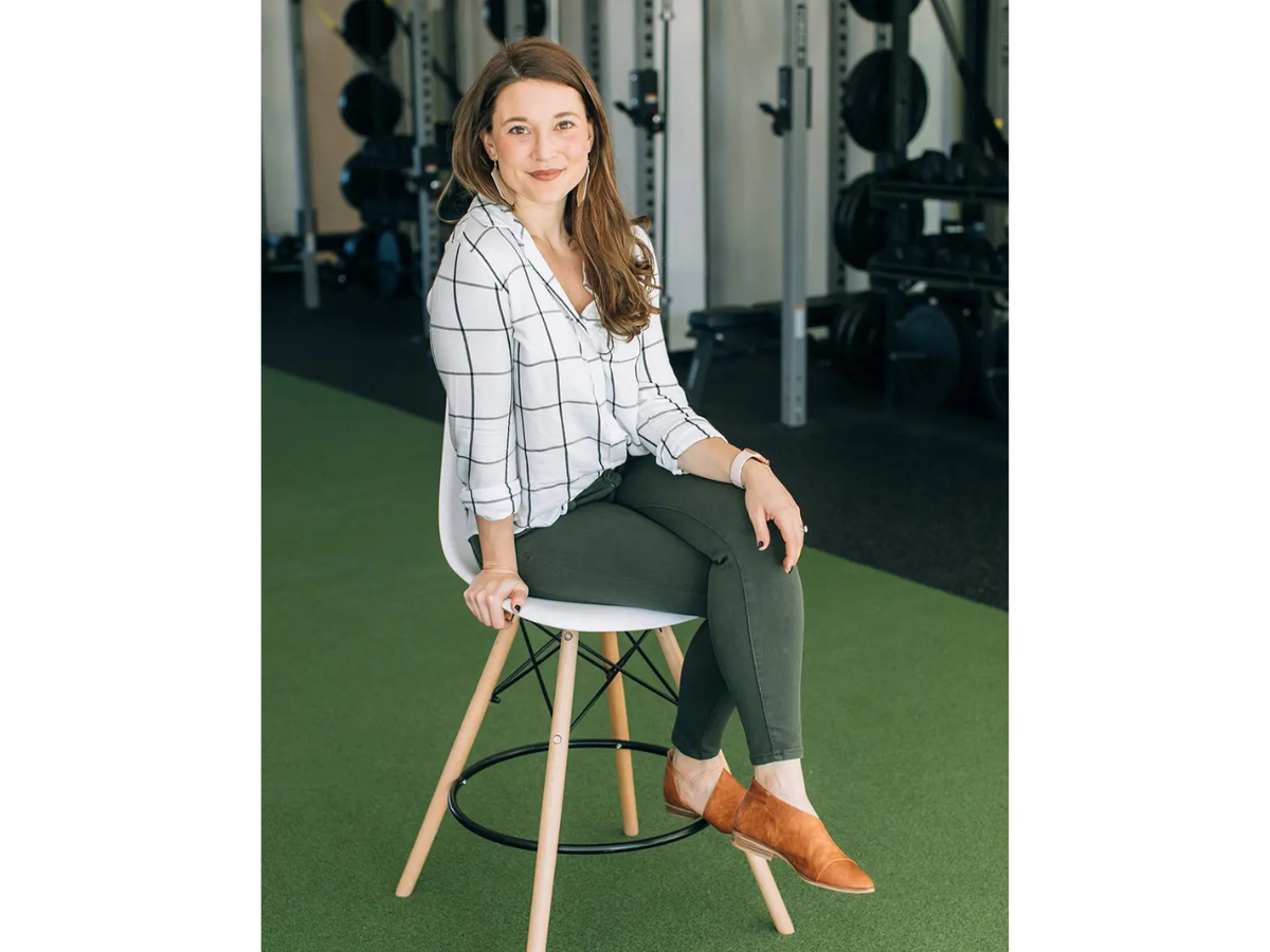 Kristin Oja, DNP, functional medicine practitioner and founder of STAT Wellness, seated in a wellness clinic before appearing on the Living to 100 Club podcast.
