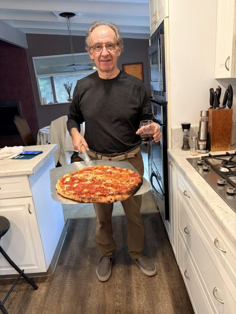 Dr. Joe making pizza as a pizzaiolo, embracing lifelong learning and new experiences.